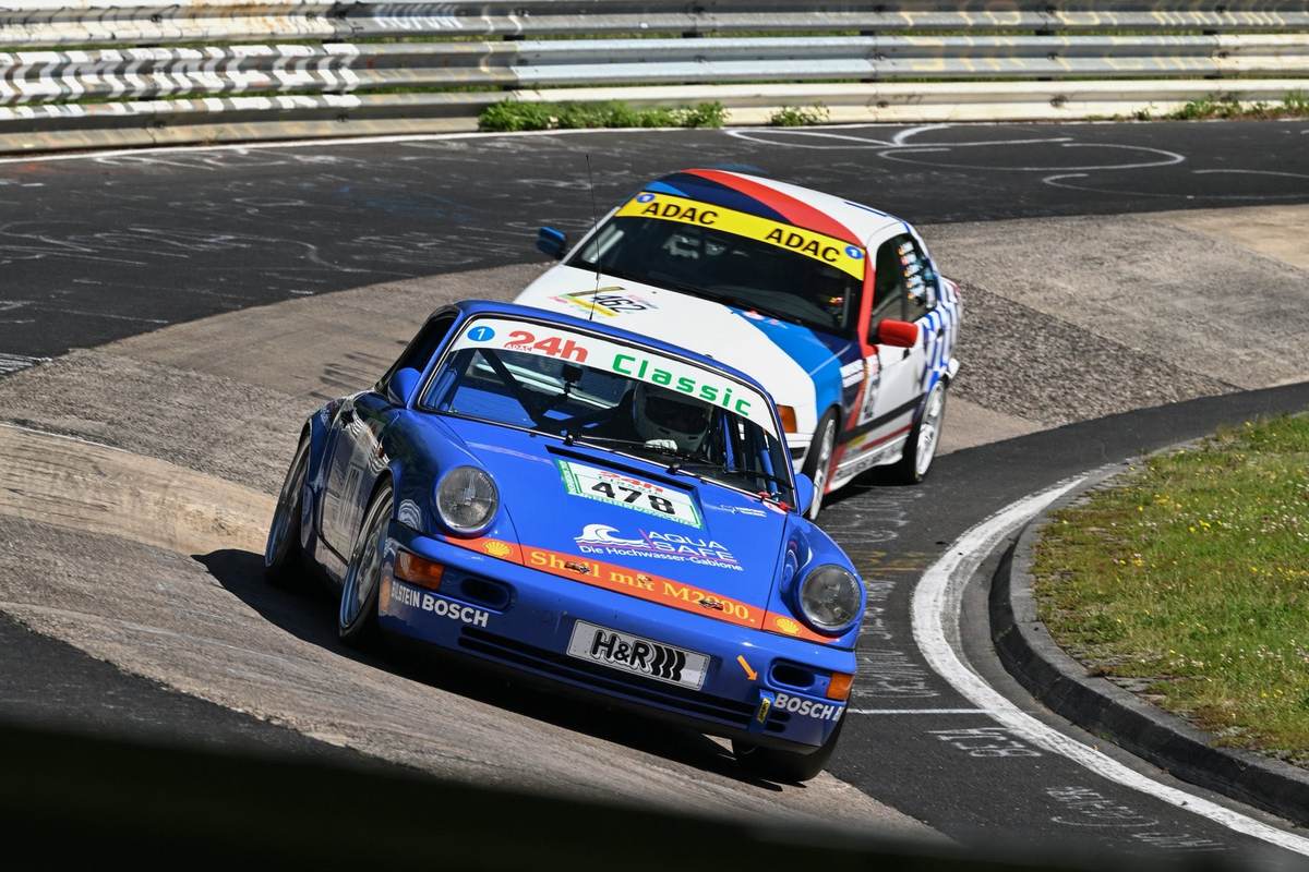 Der blaue Aimpoint-Porsche 964 mit Startnummer 470 vor einem Gegner beim ADAC 24h Classic auf der Nordschleife