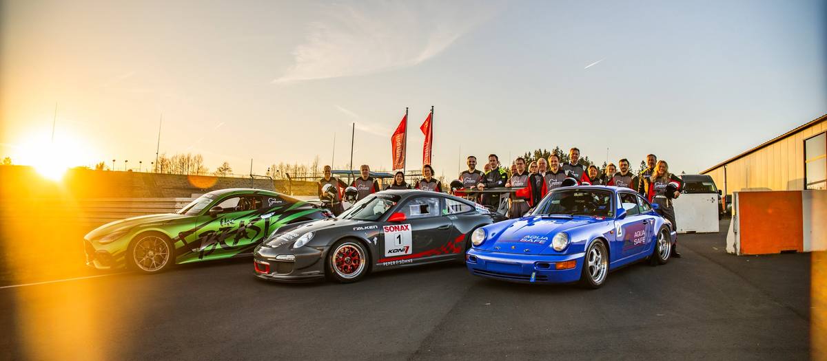 Historische Rennfahrzeuge von Aimpoint Racing im Abendlicht im Fahrerlager