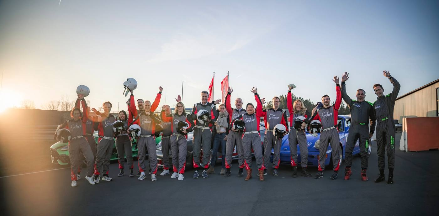 Gruppenfoto der sportpolitischen Sprechertagung der CDU mit Axel und Max Friedhoff vor den Aimpoint-Fahrzeugen am Nürburgring